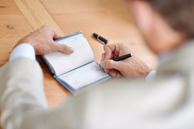 Man filling out a check.